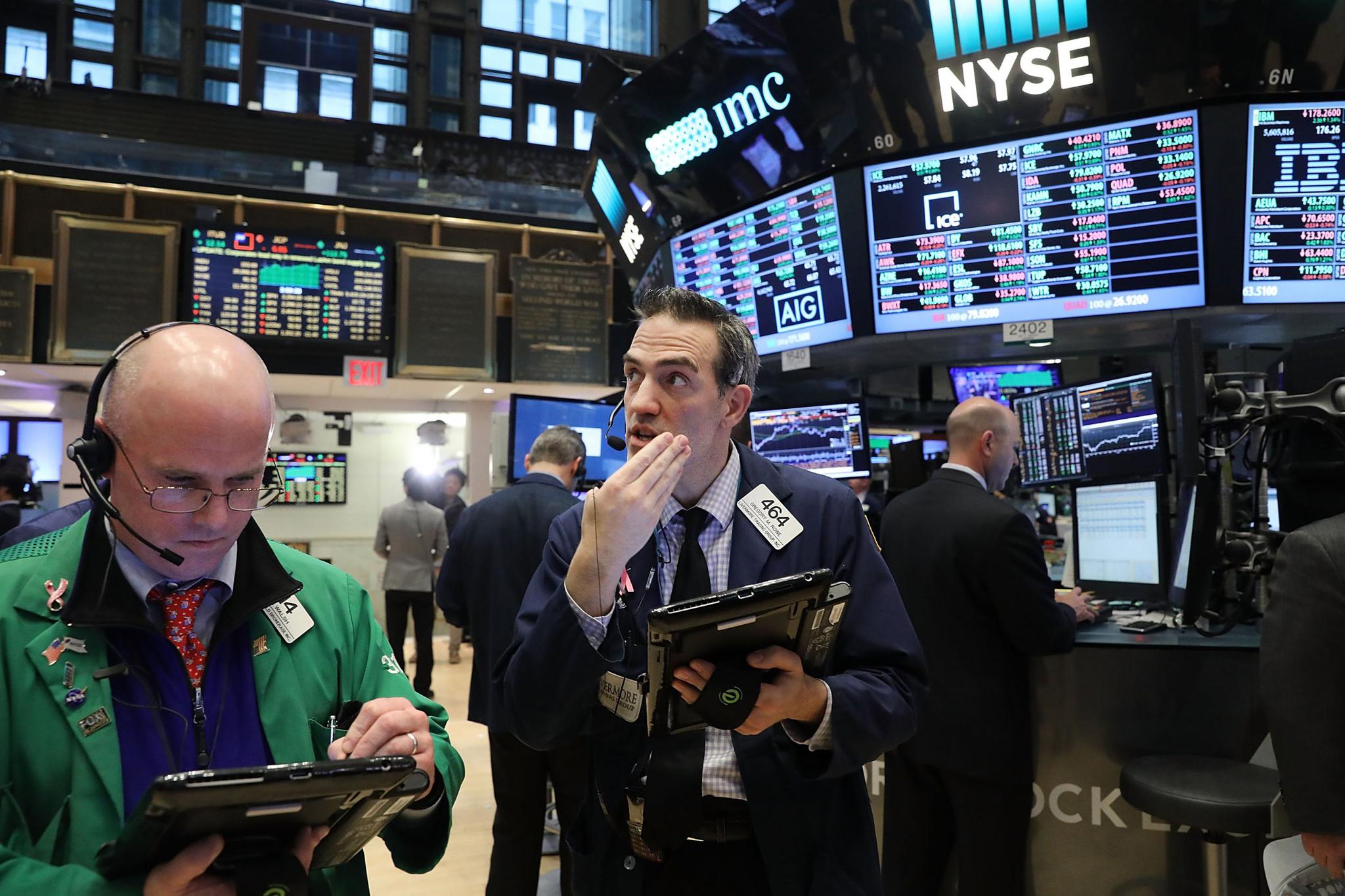 Traders work on the floor of the New York Stock Exchange (NYSE) as the Dow Jones industrial average closed above the 20,000 mark for the first time on January 25 in New York City.