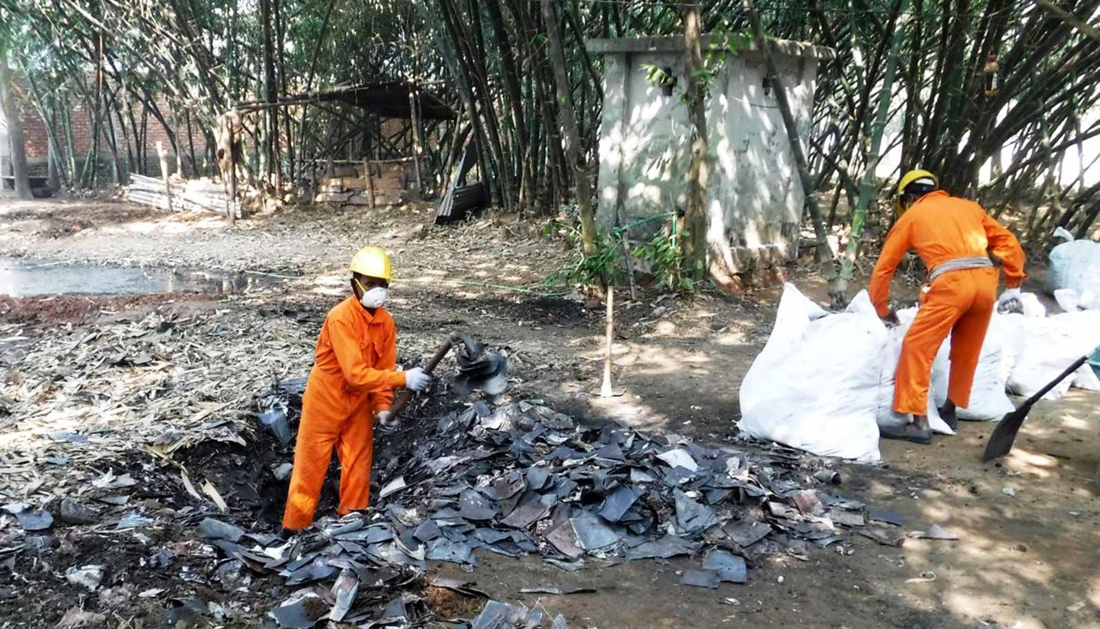 workers in orange suits in and near burn site