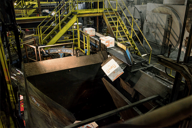 Boxes of unused medication tumble into the mouth of an incinerator at Curtis Bay Medical Waste Services in Baltimore, Maryland. (Matt Roth for ProPublica)