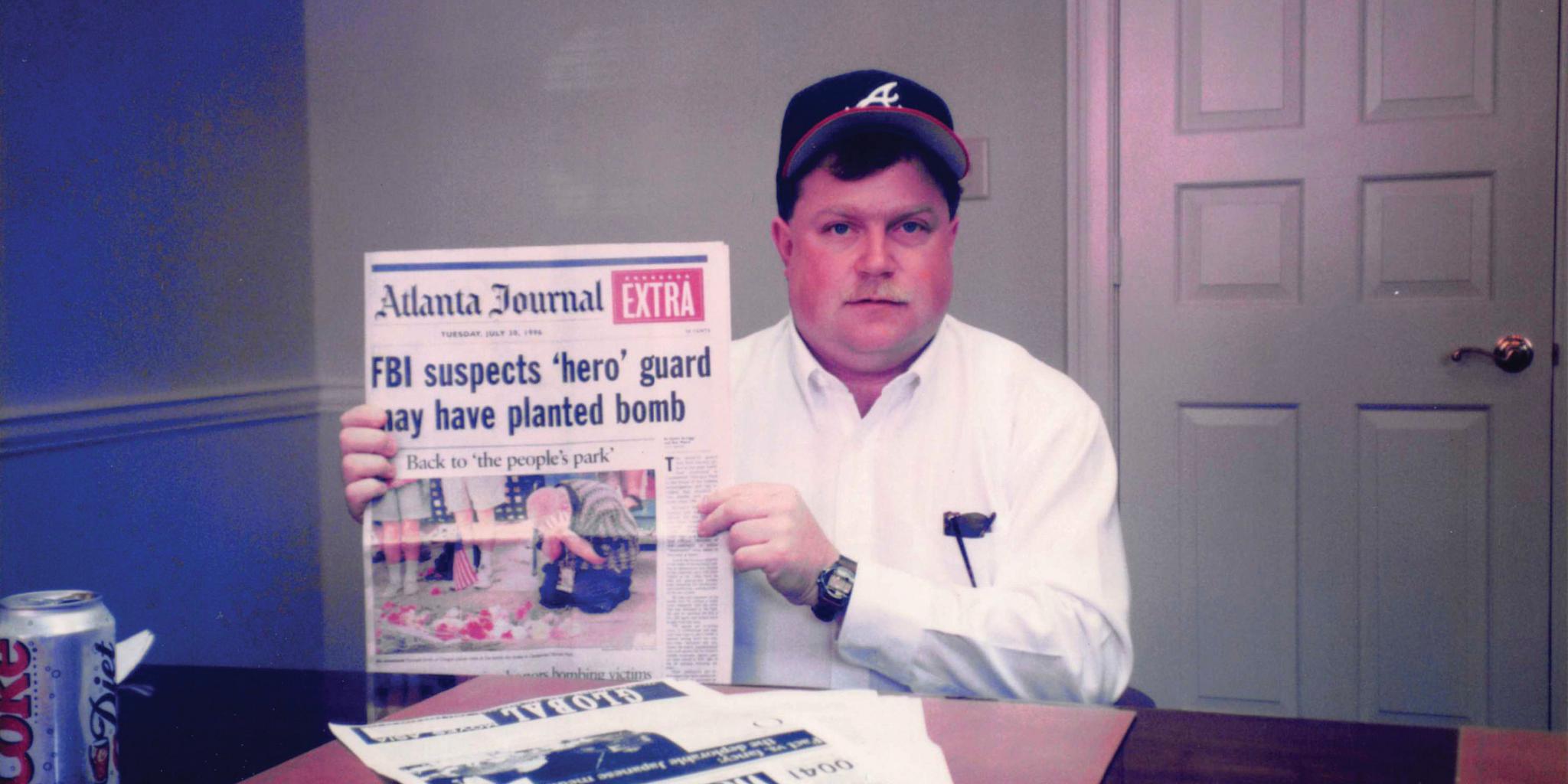 Hero No Longer Richard Jewell holds up the original Atlanta Journal-Constitution article that first identified him as the target of the FBI investigation.