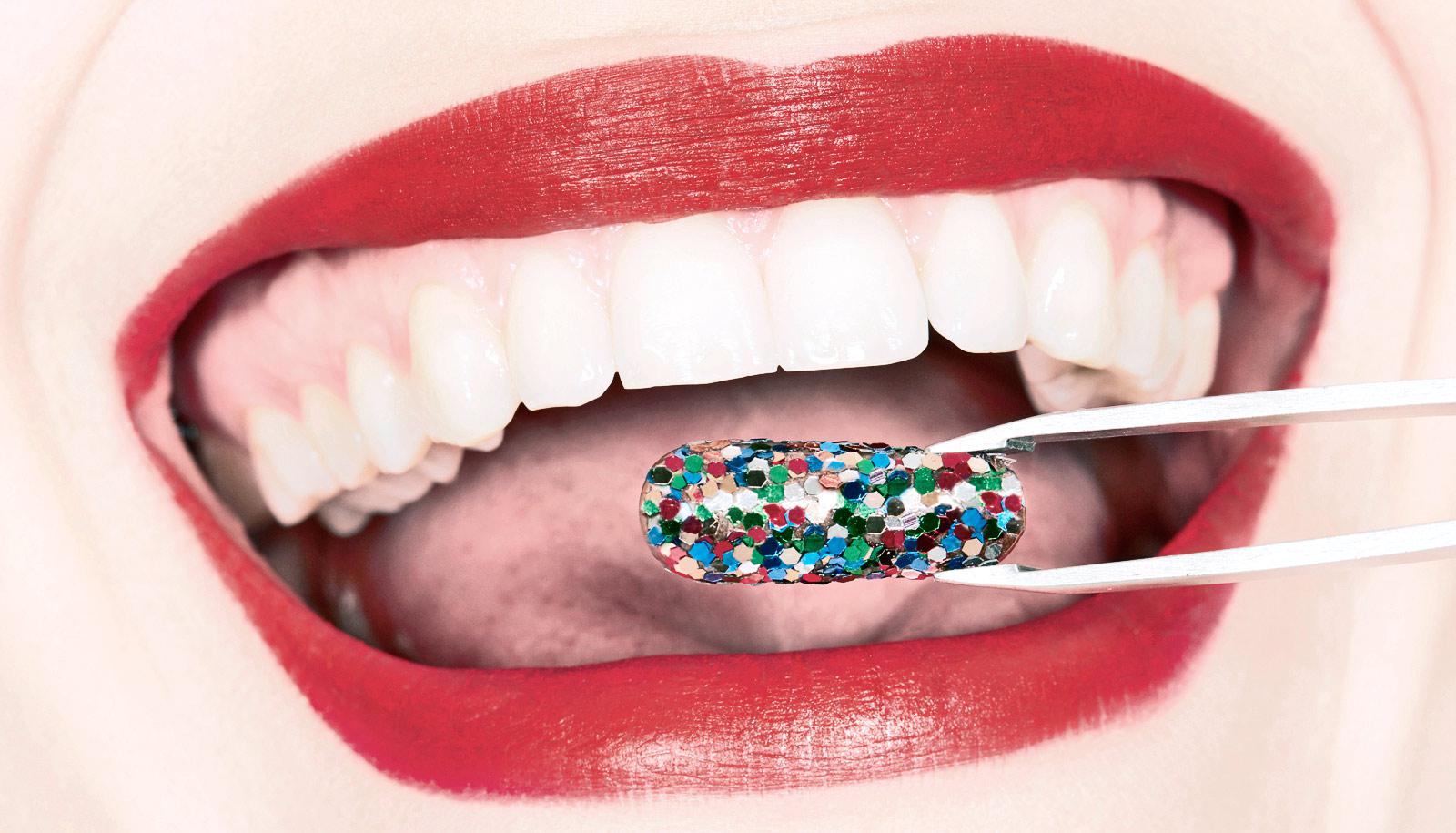 tweezers hold pill in front of mouth with red lipstick