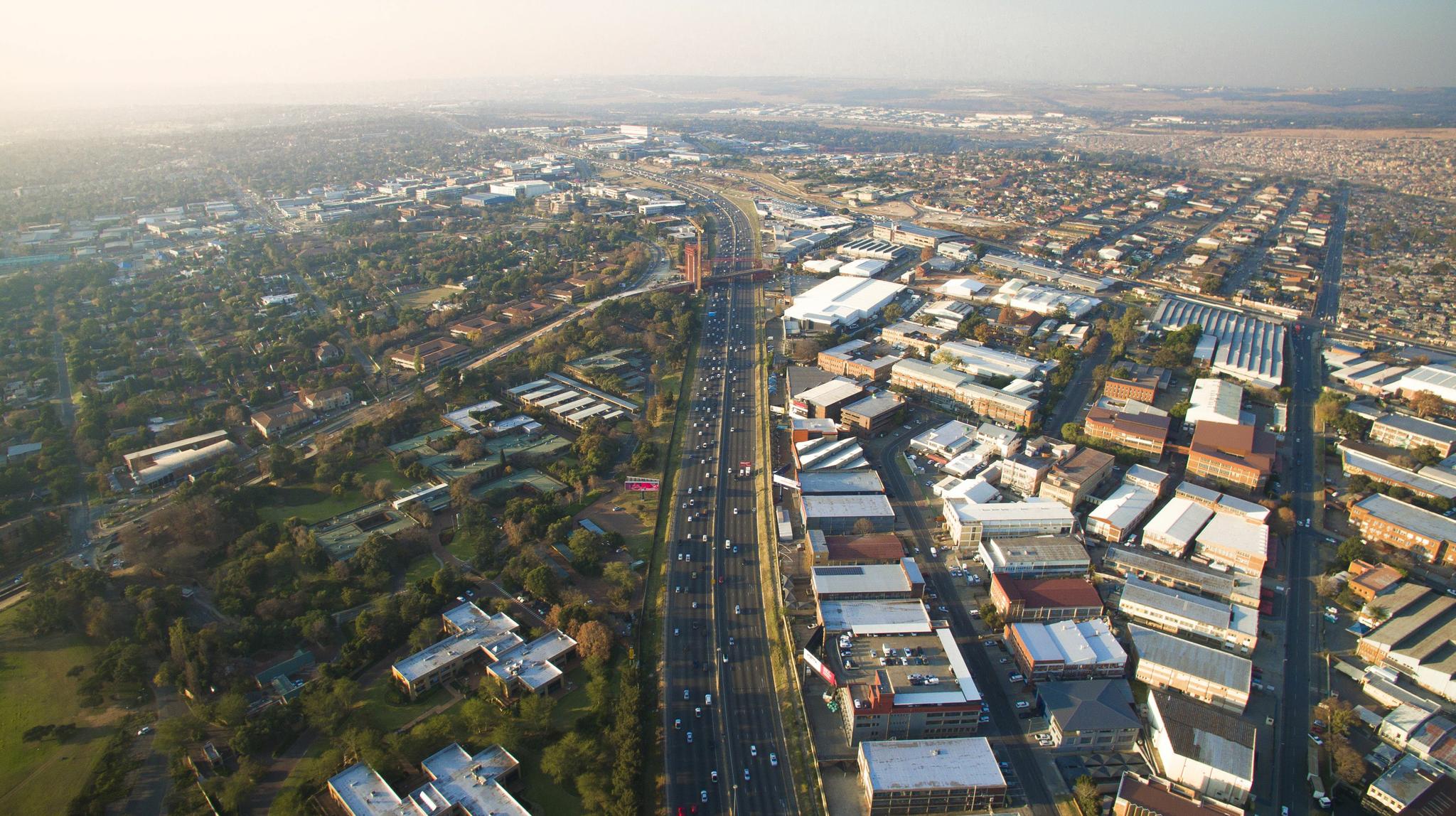 The bridge in the photograph is one of two being built that will carry bus rapid transit and pedestrians from Alexandra to Sandton. Thousands of commuters make this trip each day, on thoroughfares not designed to carry heavy pedestrian traffic. Bridges such as these, in theory, will ease access and improve the safety of commuters to Sandton.