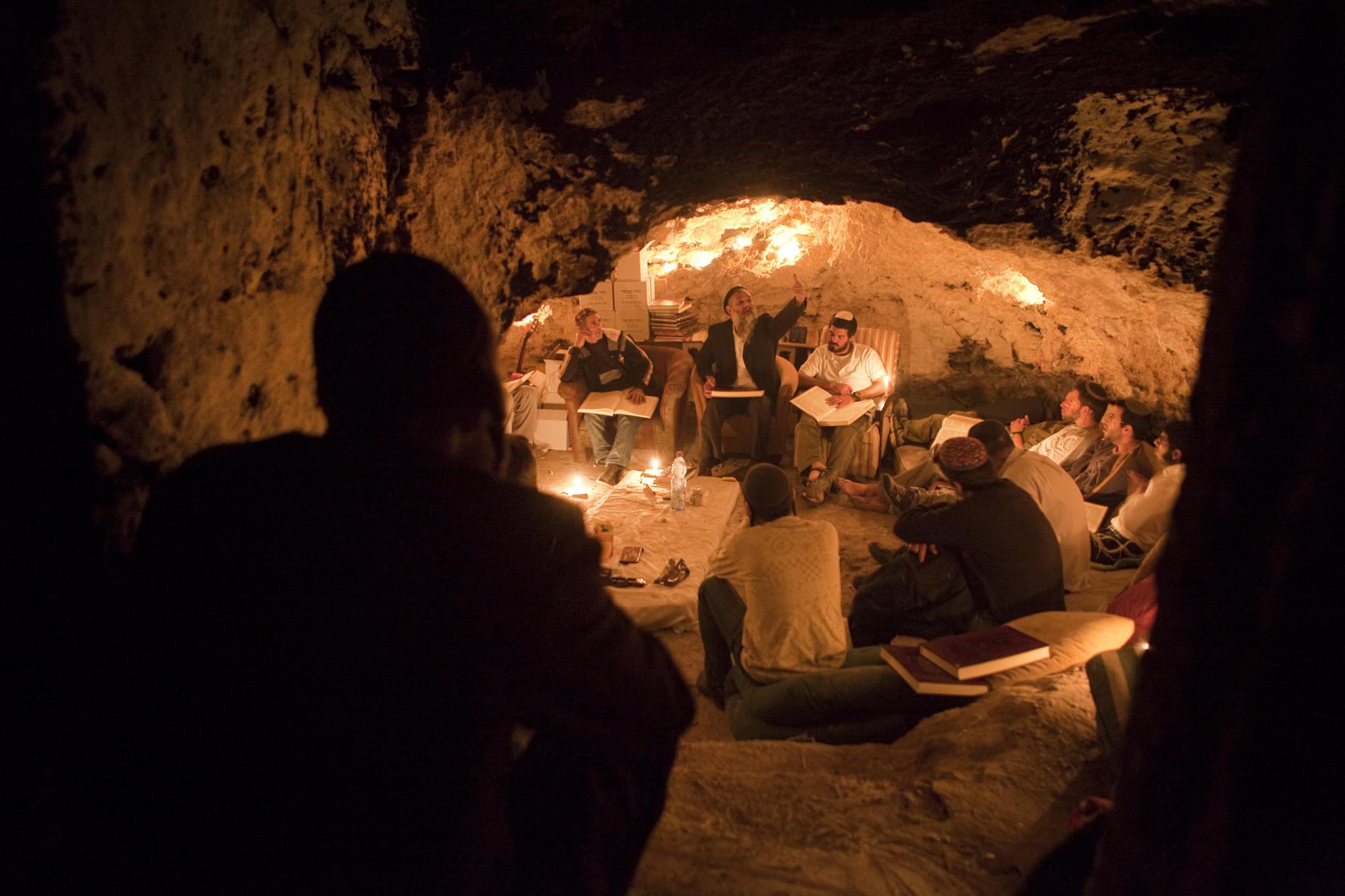 Kabbalist Rabi Uri Revach, second left, sits in front of his students during overnight Kabbalah studies inside a Jerusalem mountain cave near the village of Beit Meir on May 7, 2010. About a dozen of Orthodox Jewish men gather once a week in the cave near the holy city to study all night long the ancient Jewish mystical rite of Kabbalah, reading texts from Jewish holy books, including the Zohar texts.
