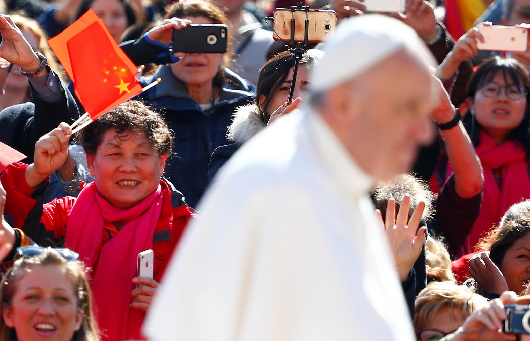 A Chinese pilgrim waves a flag as Pope Francis arrives to lead his Wednesday general audience in Saint Peter's Square, at the Vatican on March 15. While the size of the Chinese religious community is difficult to measure, studies estimate there are more than 80 million Christians inside China; some studies support the possibility it could become the most Christian nation in the world in the coming years.