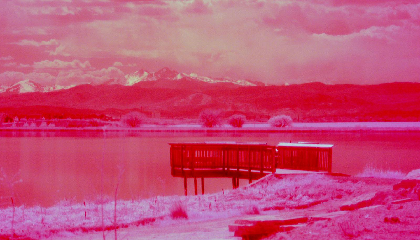 infrared (hot pink) image of dock and mountains