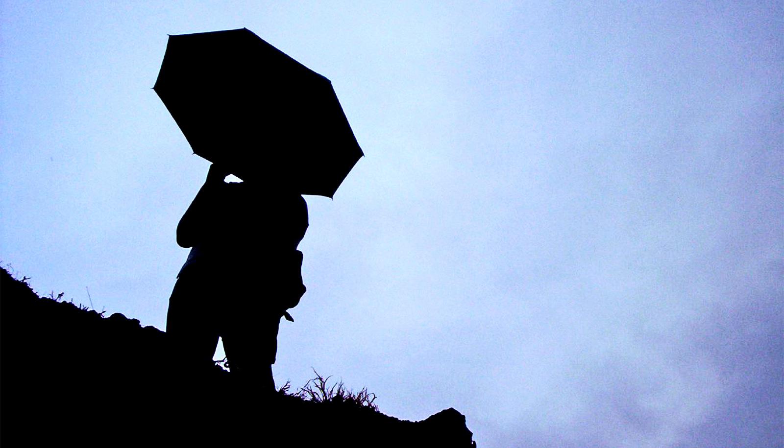 person with umbrella silhouette (Asian summer monsoon concept)