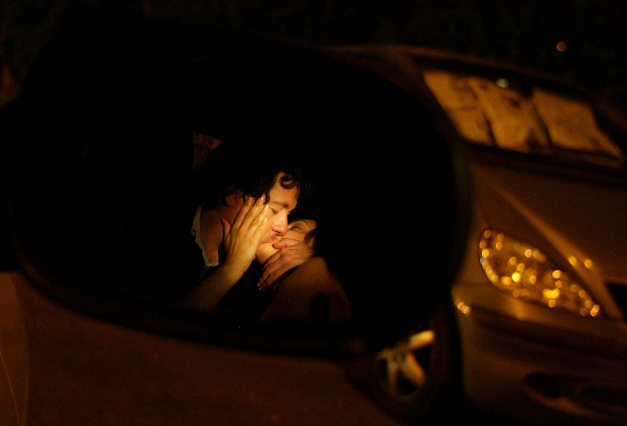 A couple kiss inside a parked car in Central Italy on early May 30, 2004.