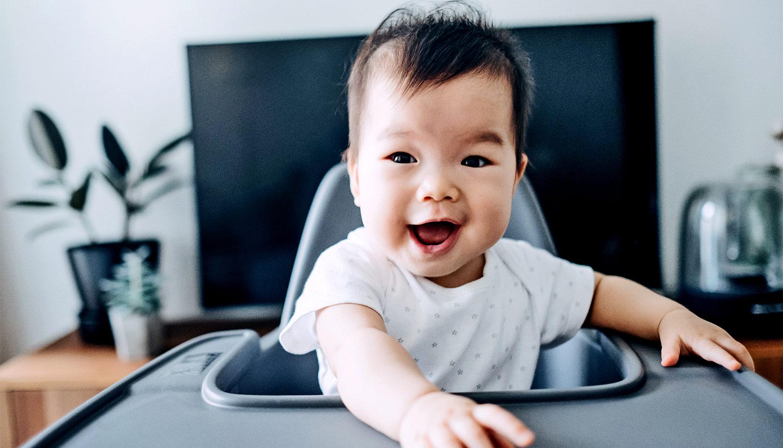 smiling baby in high chair