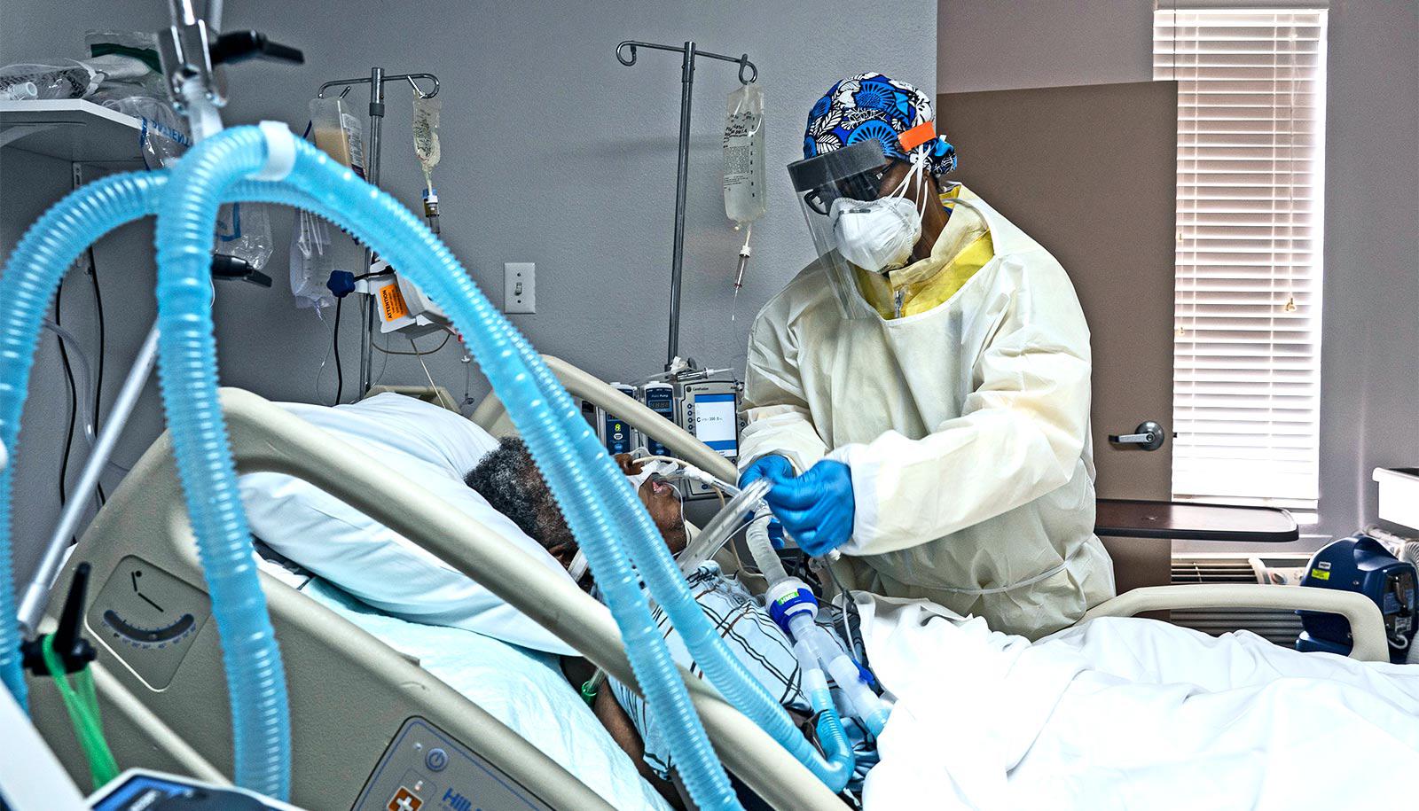 A health worker cares for a patient in bed