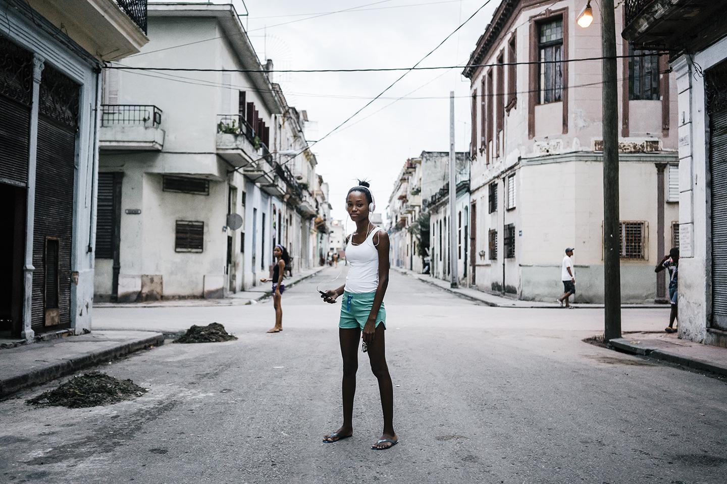 Anna Marie Mesa, 16, listens to music on her smartphone in Centro Havana. Technology is leapfrogging the infastructure in Cuba where citizens went from landlines to smartphones in a matter of months.