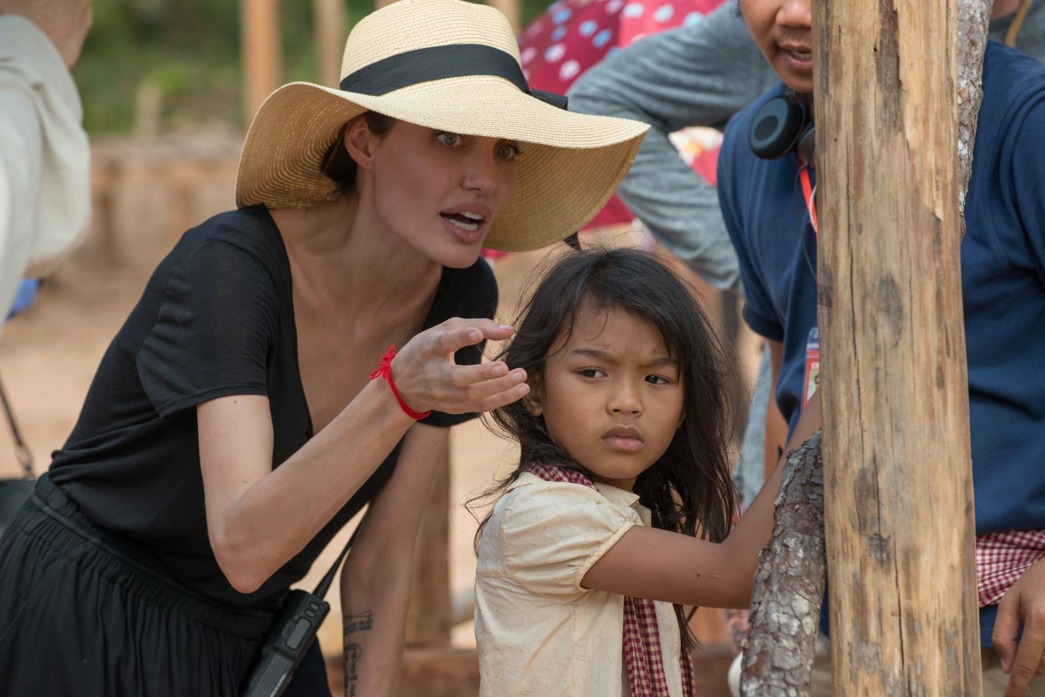 Angelina Jolie speaks with Srey Moch Sareum behind the scenes during production on the film.