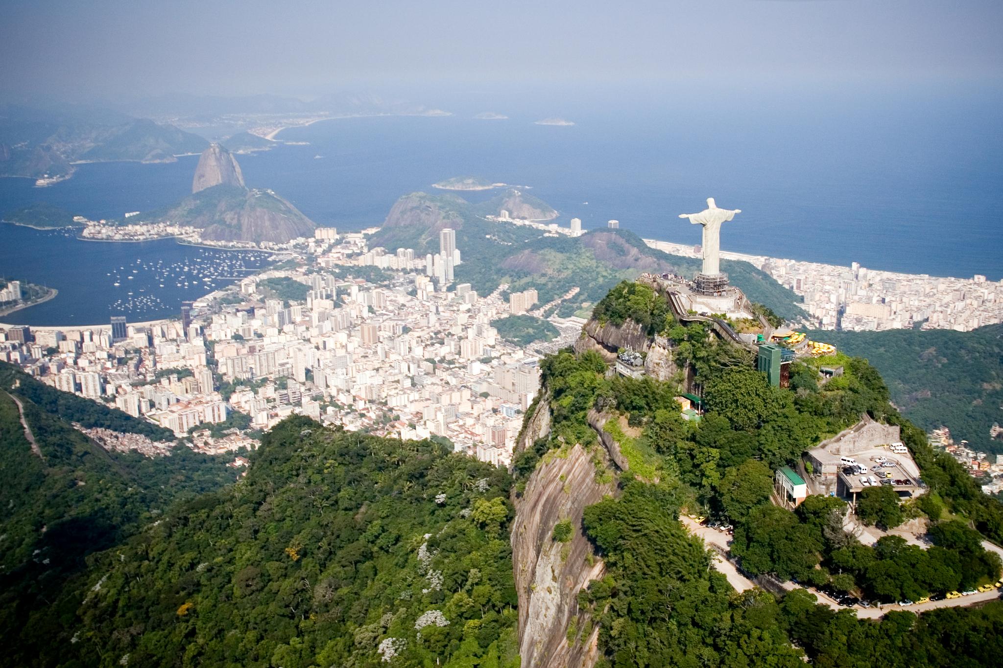 An aerial view of Rio de Janeiro features landmarks Christ the Redeemer and Sugarloaf Mountain.