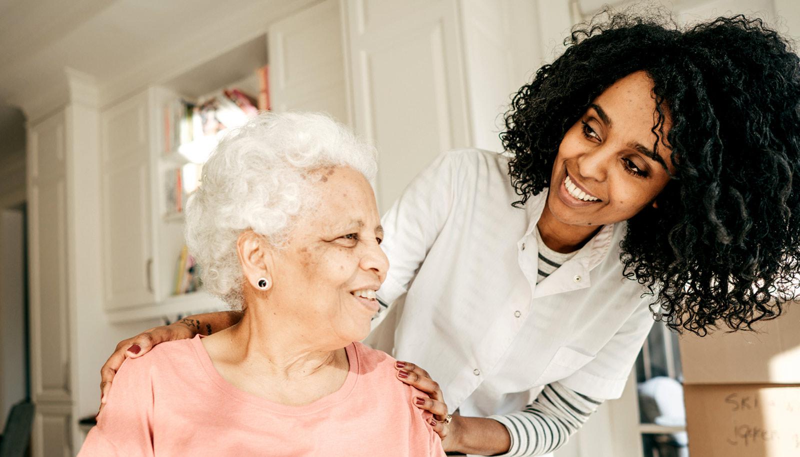 younger woman in white lab coat with elderly relative