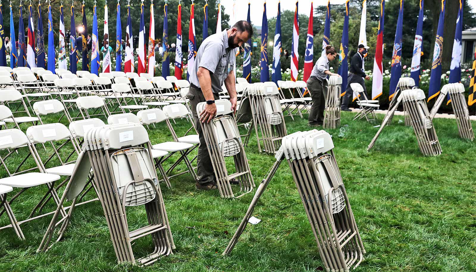 A man sets up folding chairs on the White House's Rose Garden lawn