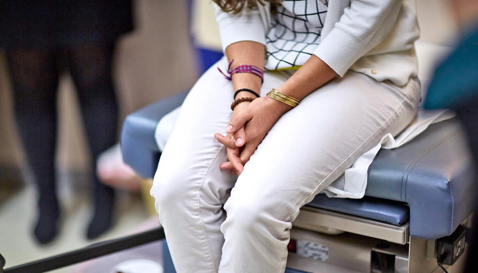 person sits on exam table