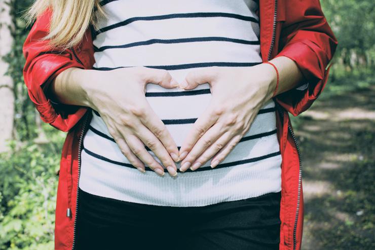 Gut Health: What You Need to Know, by Nichelle Antoque. Photograph of woman holding her stomach.