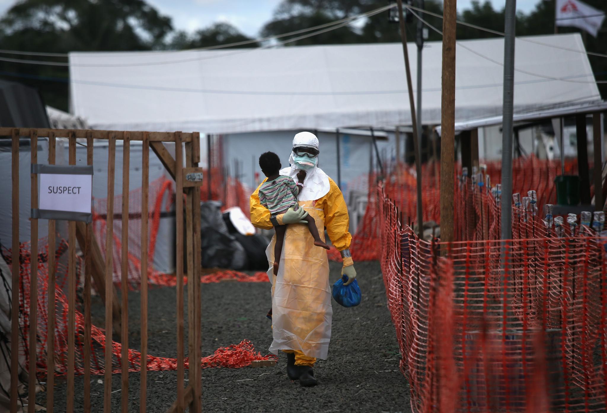 A Doctors Without Borders health worker carries a child suspected of having Ebola in October 5, 2014 in Paynesville, Liberia. A new scoring system that calculates the severity of an Ebola case could help fight outbreaks and save lives.