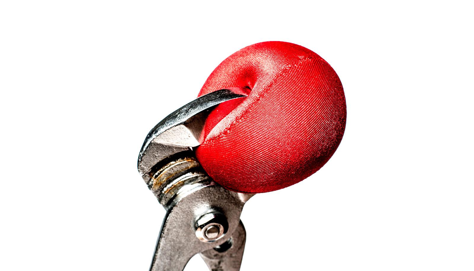 wrench squeezes red ball