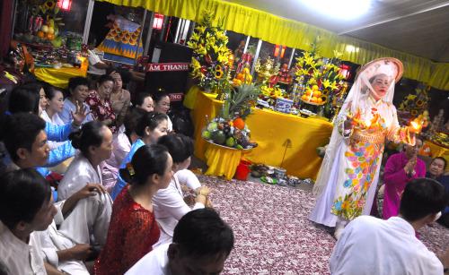 Practitioner Kim Chi performs a lên đồng ritual for her temple delegation on a boat at the Điện Hòn Chén festival. Loa / Jenny Lý