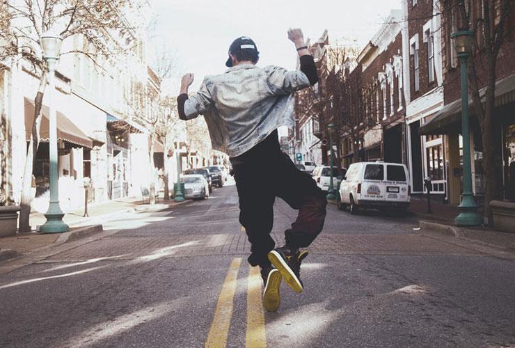 Flipping your Mindset: The Healing Power of Affirmations, Mindfulness and Gratitude by Daniel Wittler. Photograph of a man skipping through the city by Andrew Hunter