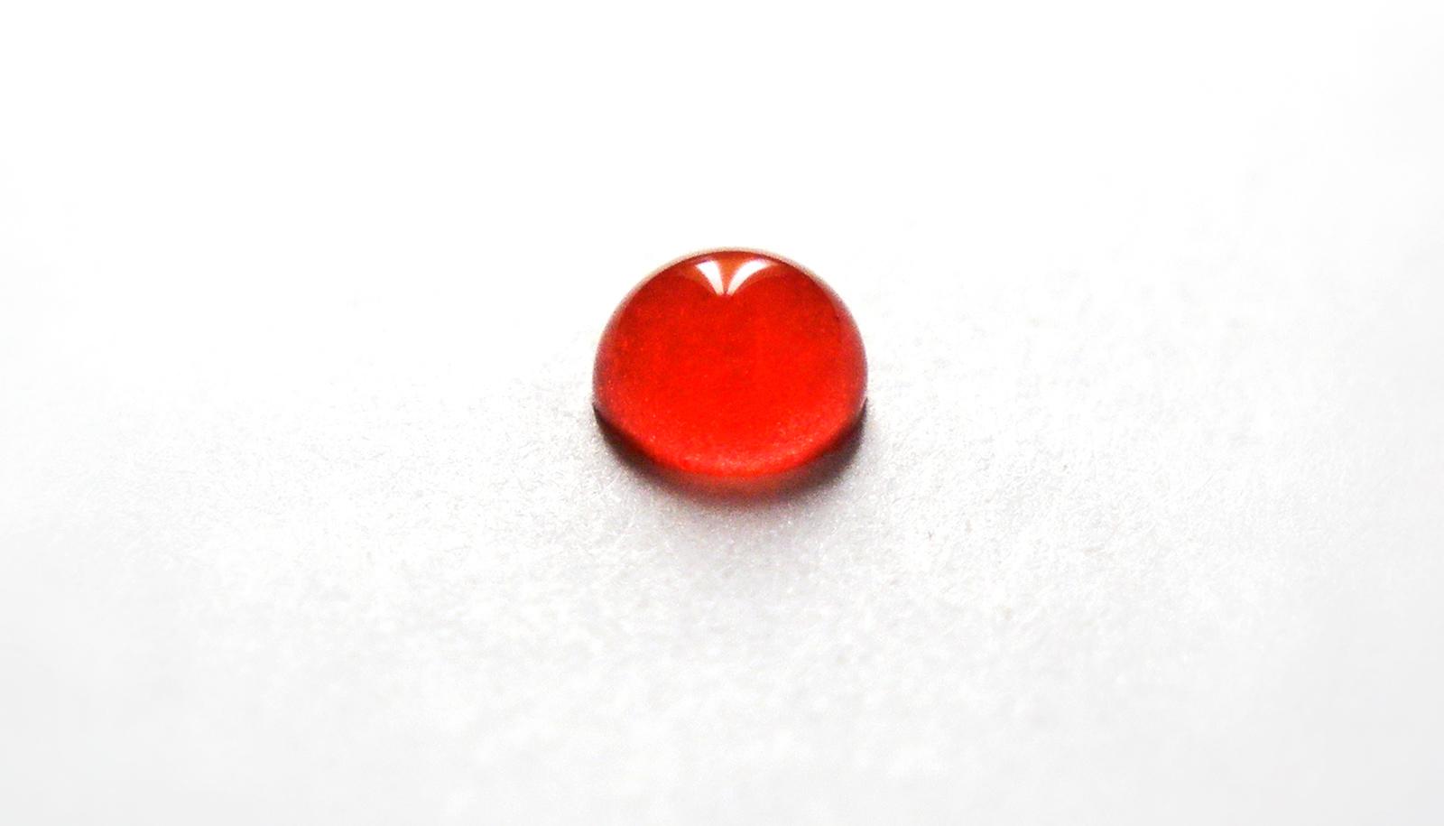 A drop of blood sits on a white surface