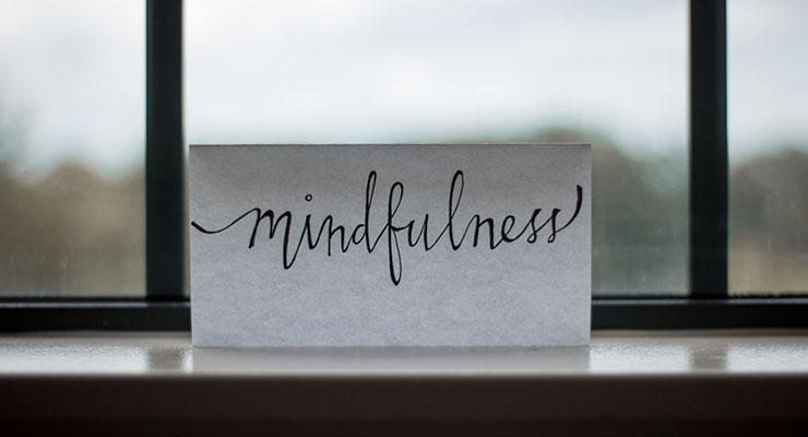 Life After Addiction: How Mindfulness Improved My Way of Life by Cassidy Webb. Photograph of a note card that reads "mindfulness" placed on a window by Lesly Juarez