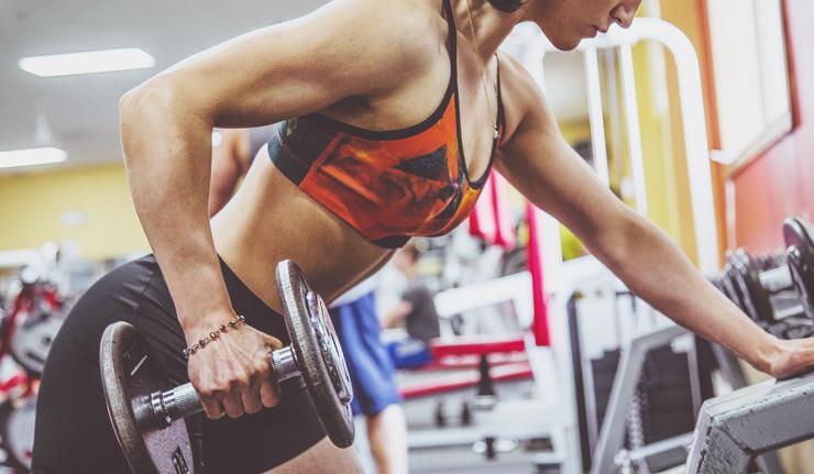 Resistance Weight Training for Beginners by Agatha Singer. Photograph of woman using dumbbell at gym by Alora Griffiths