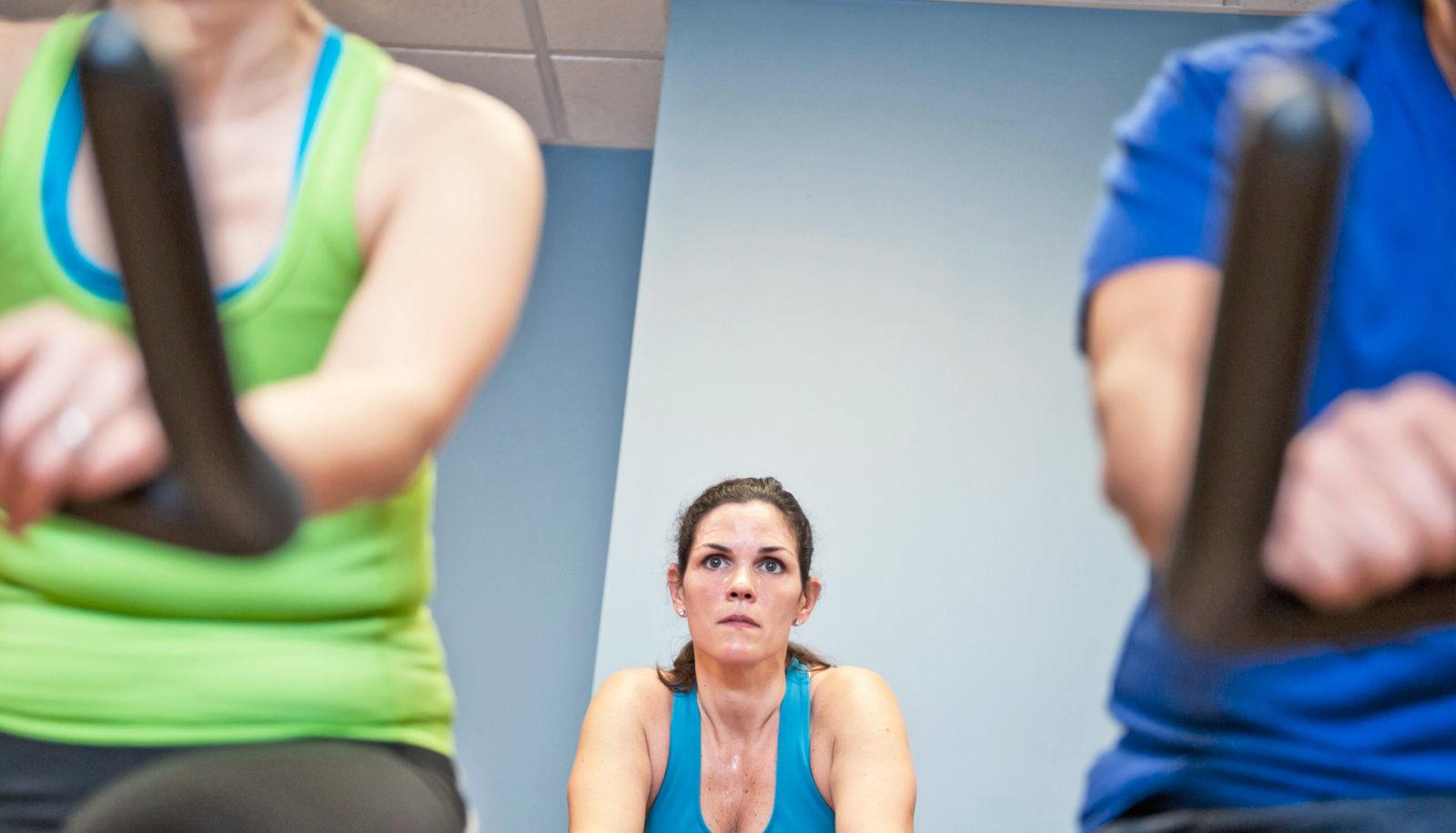 woman between two other people in spin class