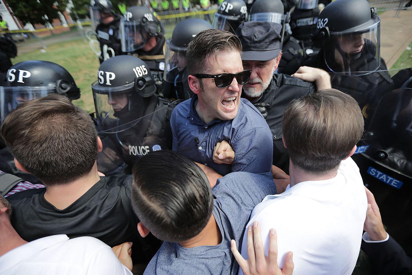 White nationalist Richard Spencer, center, and his supporters clash with Virginia State Police in Emancipation Park after the "Unite the Right" rally was declared an unlawful gathering on August 12, 2017, in Charlottesville, Virginia.