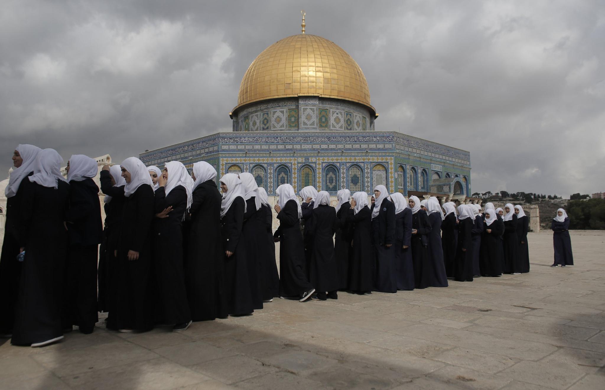 Palestinian school girls walk in line past the Dome of the Rock at the Al-Aqsa mosque compound in Jerusalem's Old City on October 27, 2015. Israeli lawmakers on Sunday approved a new version of a nation-state bill that would demote Arabic as an official language.