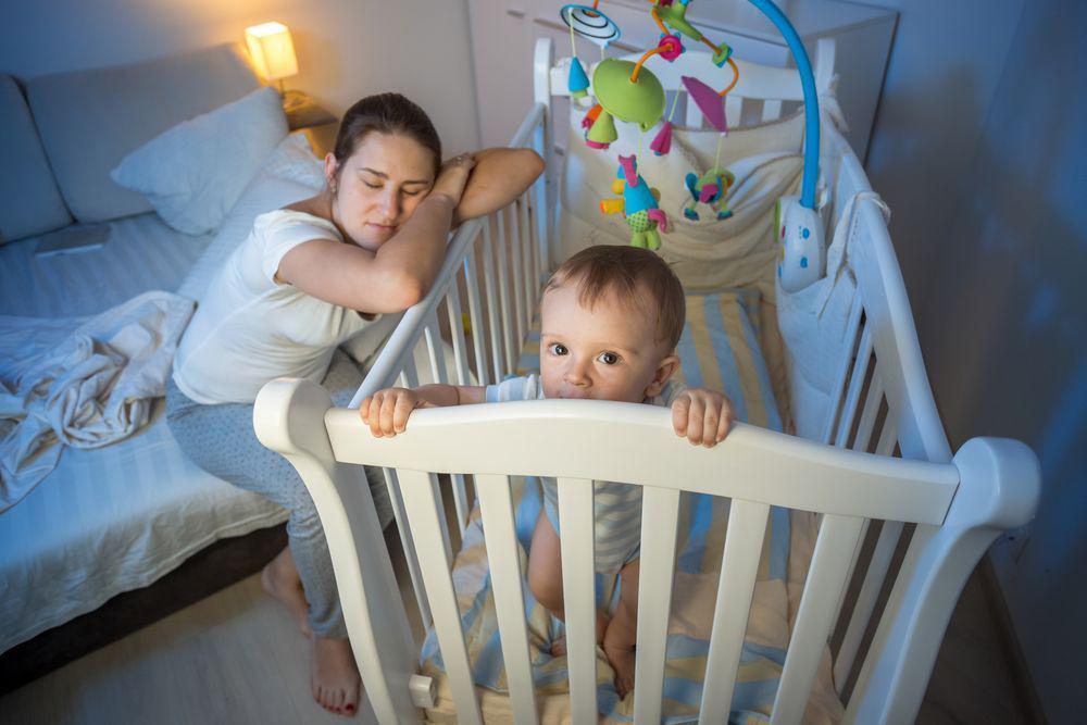 Mom Tired While Baby Is Awake Inside Crib