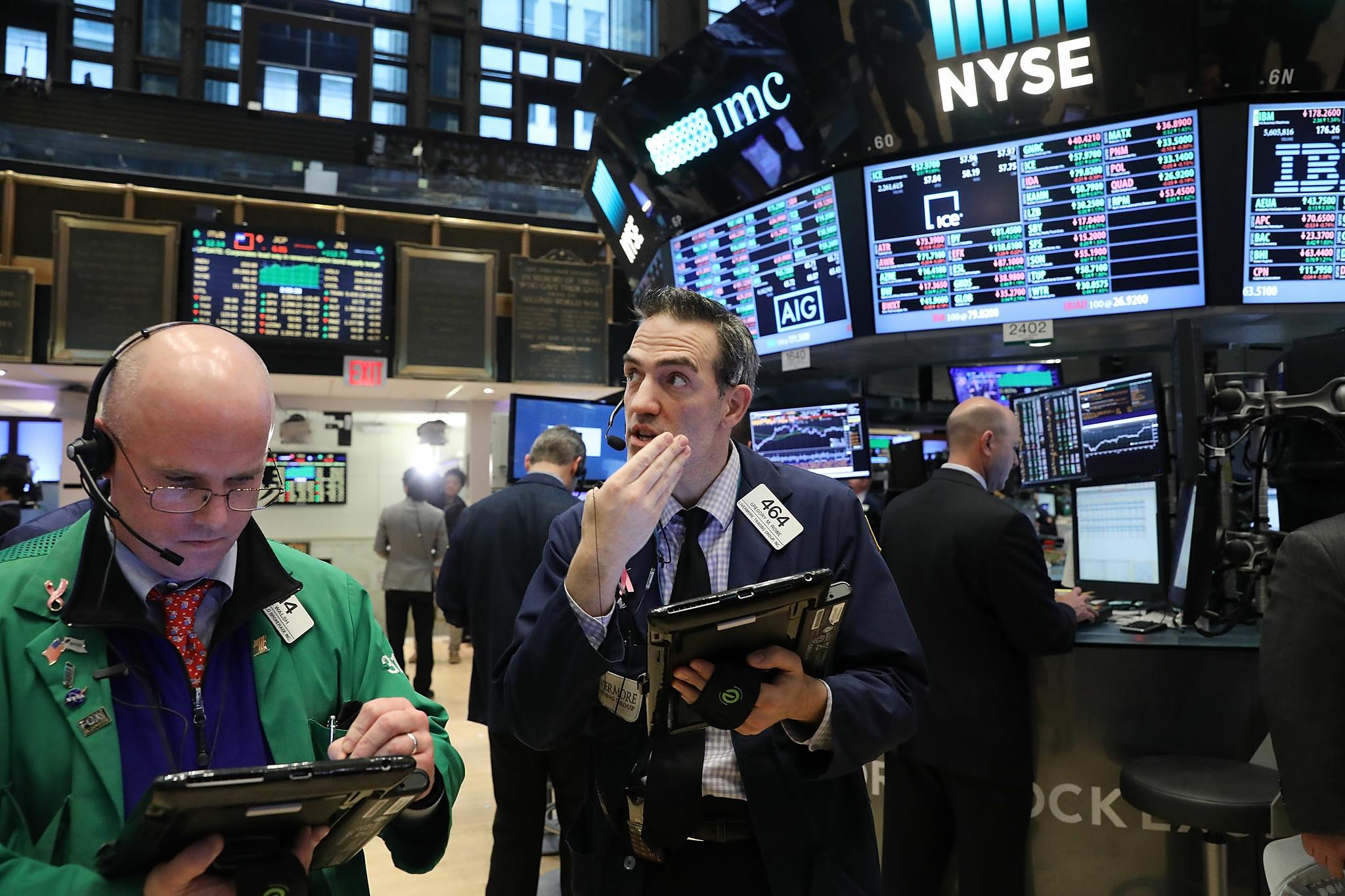 Traders work on the floor of the New York Stock Exchange (NYSE) as the Dow Jones industrial average closed above the 20,000 mark for the first time on January 25 in New York City.