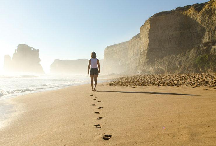 From Medication to Meditation: A Journey From Depression to Peace by Laura Bishop. Photograph of woman waling on sandy beach by Brian Mann