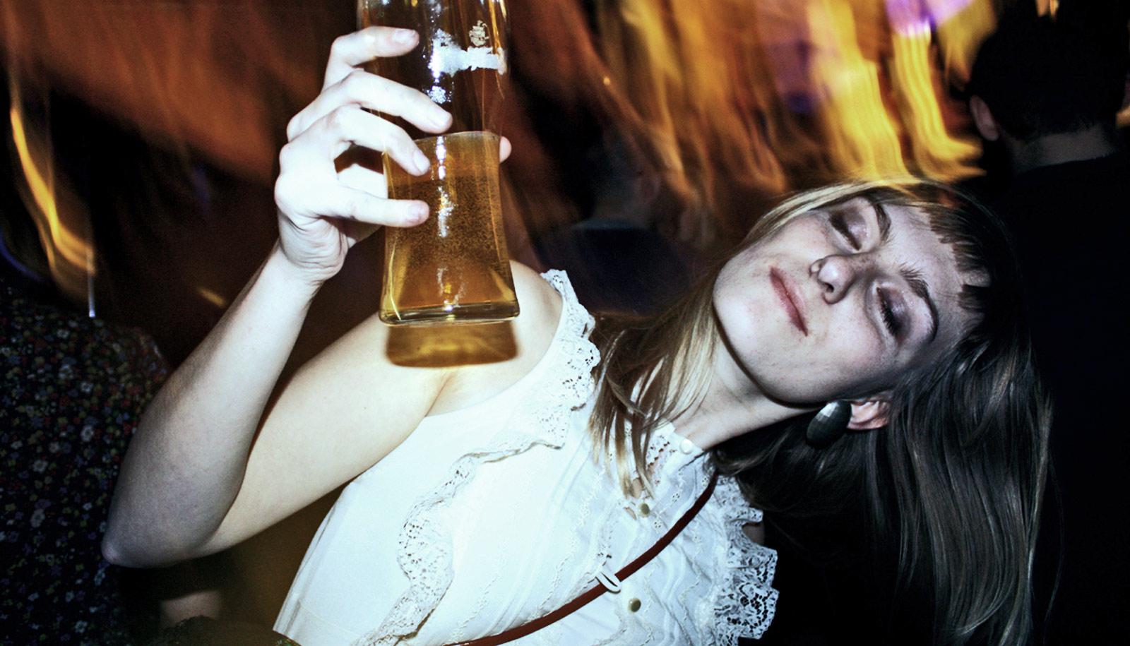 woman with head to the side holding beer