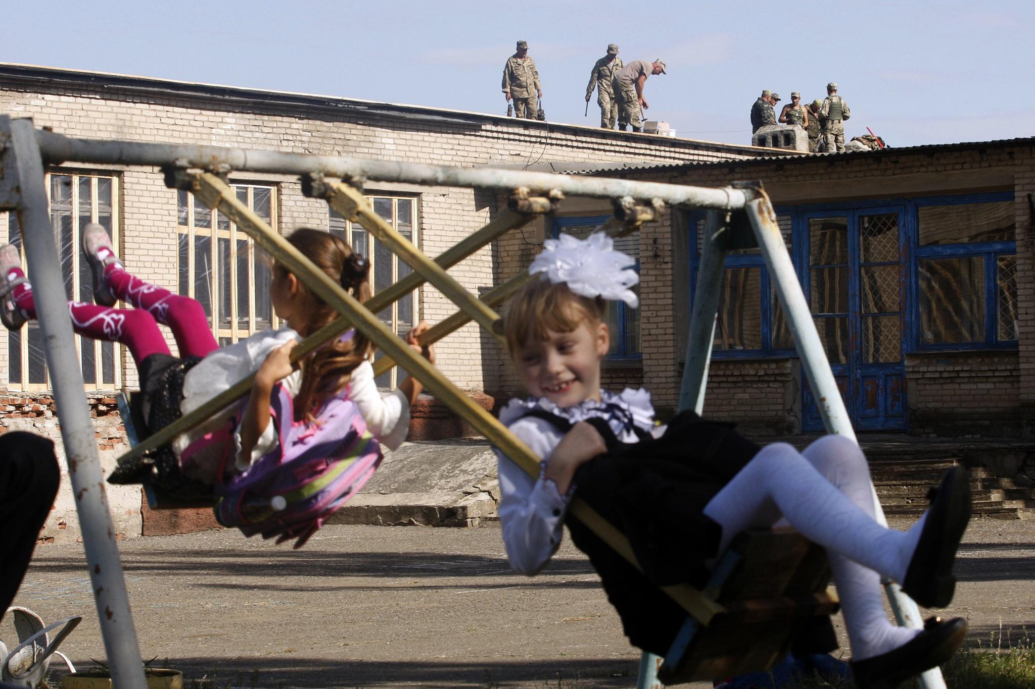 Ukrainian servicemen repair the roof of a kindergarten in the town of Luganskoye in the Donetsk region on September 30, 2015.